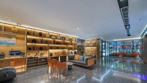 A modern lobby with a seating area, a reception desk, and a large bookshelf. - The Origin Hotel (Wenzhou Lucheng Road Guanghua Bridge) (Wenzhou)