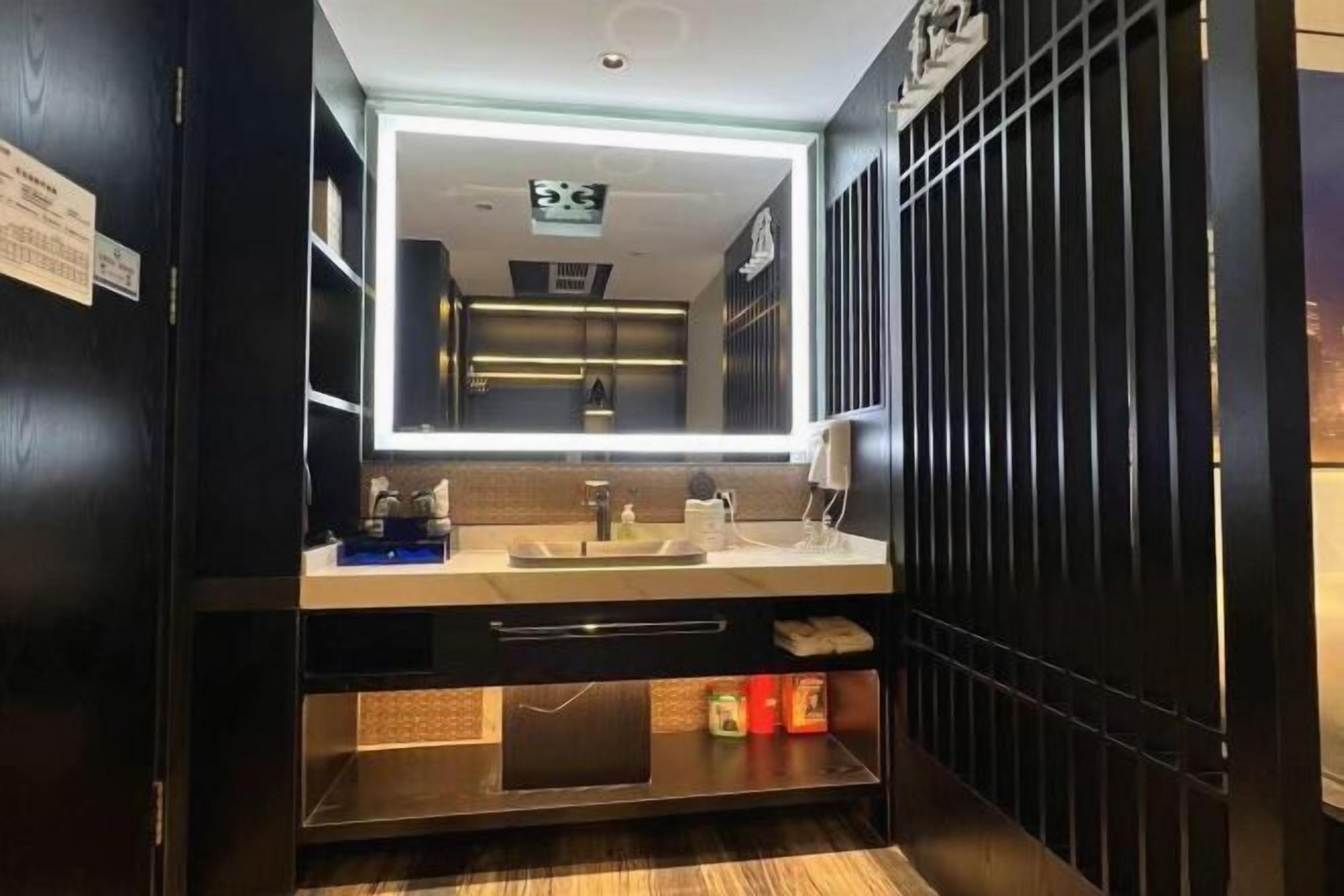 A modern bathroom with a large mirror, a sink, and a vanity.