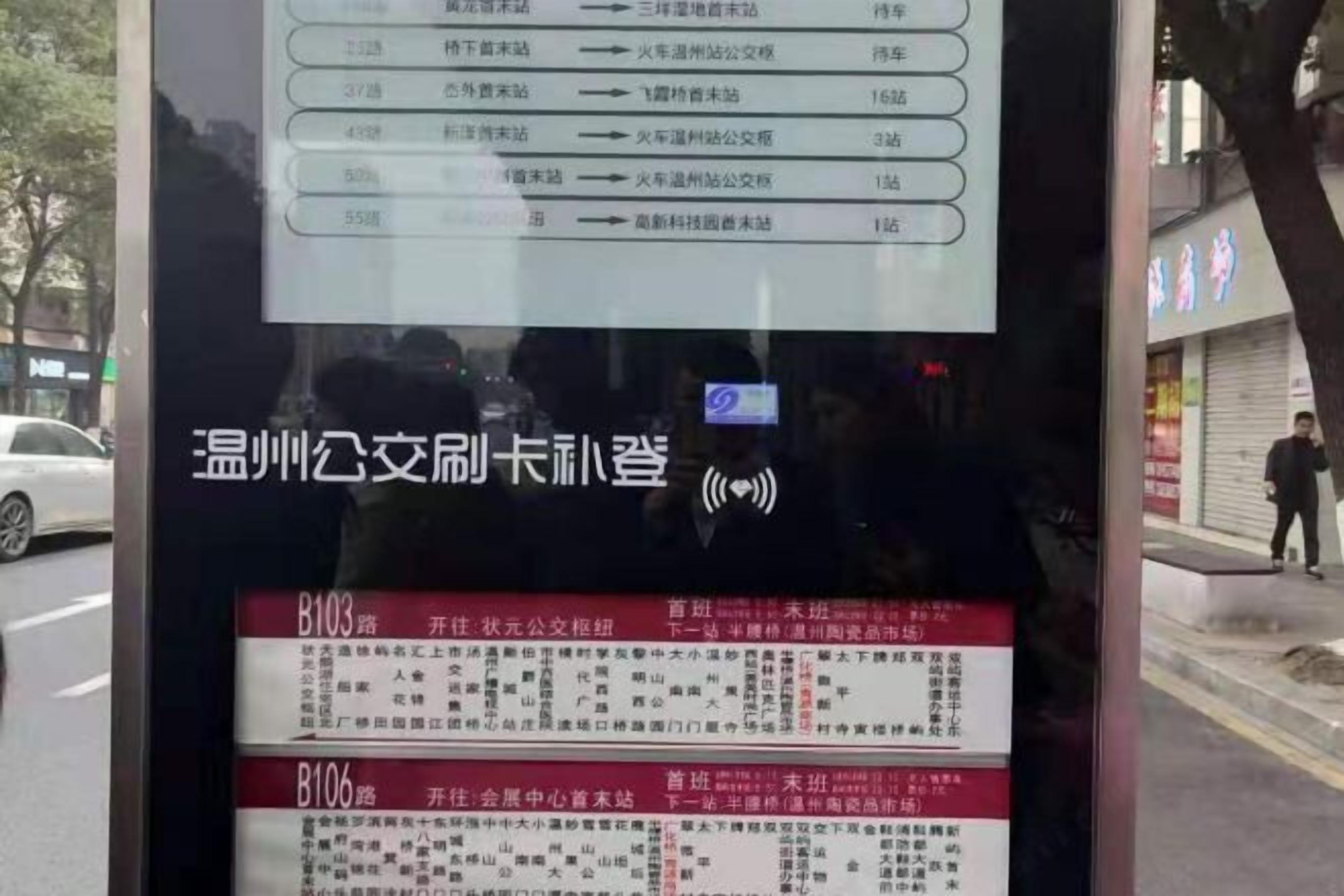A bus stop shelter with a timetable and route information.