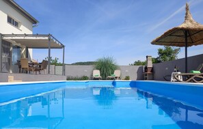 Una piscina al aire libre, tumbonas