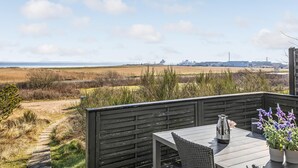 A deck with a view of the sea and industrial buildings. - 2 bedroom beautiful home in Rømø (Romo)
