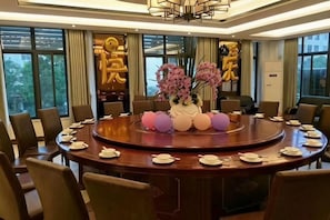 Une salle de conférence équipée d’une table ronde, de chaises et d’un arrangement floral en guise de décoration centrale.