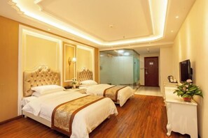 A hotel room with two beds, a wooden floor, a white console table with a plant, and a mirror on the wall. - Shangcheng lijingyuan Hotel (Shangcheng)