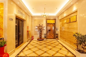 Un vestíbulo de hotel con piso a cuadros, un candelabro y un adorno con forma de timón de barco.