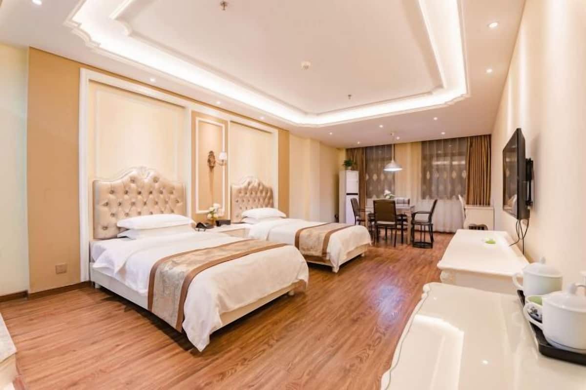 Una habitación de hotel con dos camas, un escritorio y un comedor.