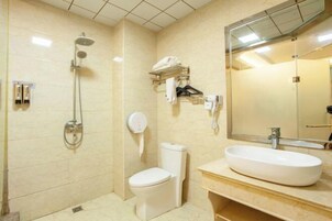 A bathroom with a toilet, a sink, a mirror, a towel rack, and a shower.