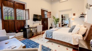 A modern hotel room with a bed, desk, and seating area. - Kuxtal Hotel Boutique (Mérida)