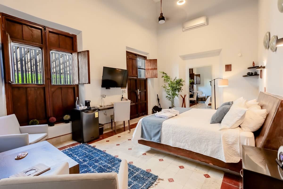 Una habitación de hotel moderna con cama, escritorio y zona de estar.
