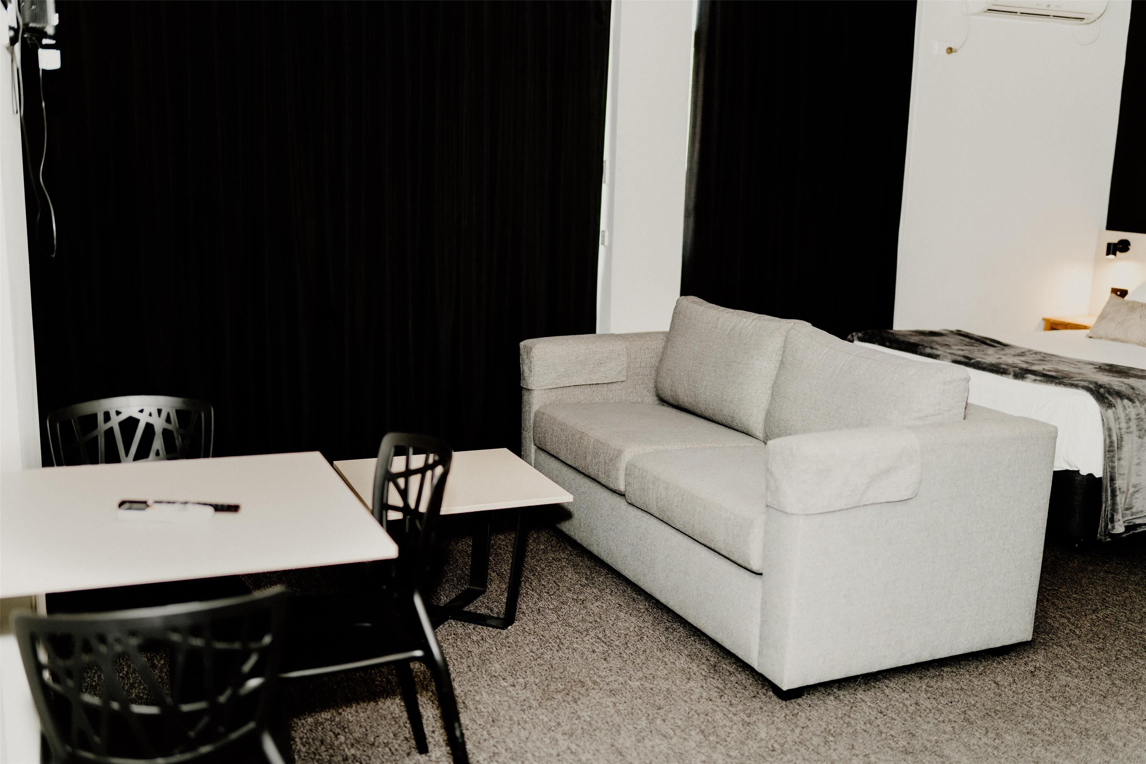 Una habitación con un sofá blanco, una mesita y una silla.