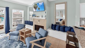 A living room with a fireplace, a TV mounted on the wall, and a large mirror. - Townhome on the water. Sleeps8. Pet friendly! (Corpus Christi)
