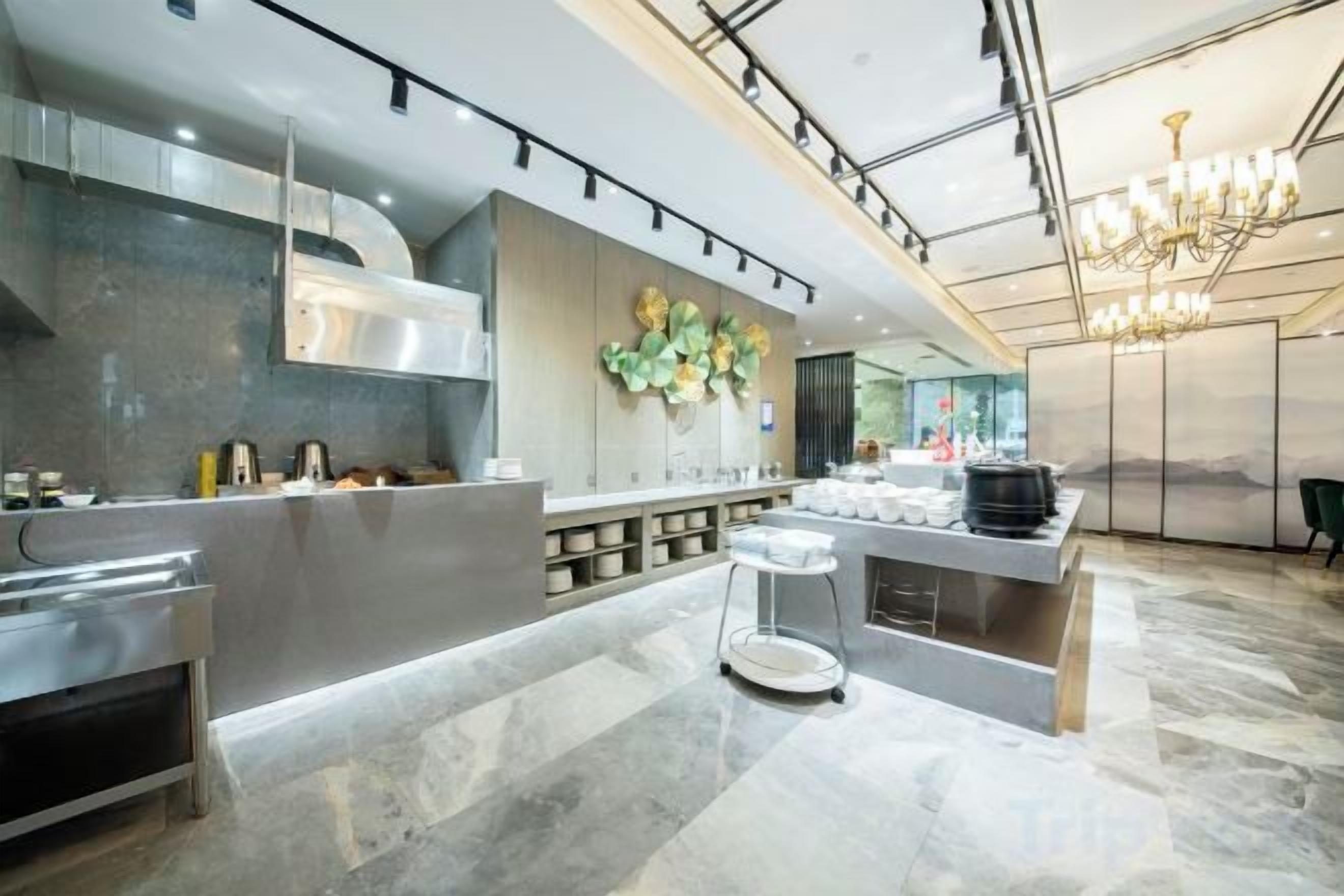 Una cocina moderna con una isla central, electrodomésticos de acero inoxidable y una araña.