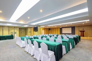 A conference room with rows of tables and chairs, a podium, and a screen. - New Beacon International Hotel (Enshi Cultural Center) (Enshi City)
