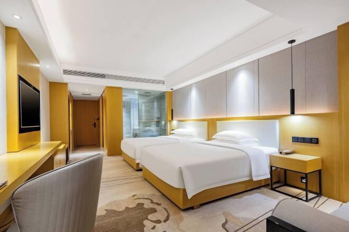 Una habitación de hotel con una cama, un escritorio, una silla y un televisor.