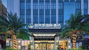 A hotel with a modern facade, a prominent entrance, and a well-lit sign.