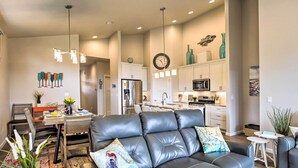 A modern living room with a leather sofa, dining area, and kitchen. - Stunning Neskowin Gem: View of Cascade Head! (Neskowin)