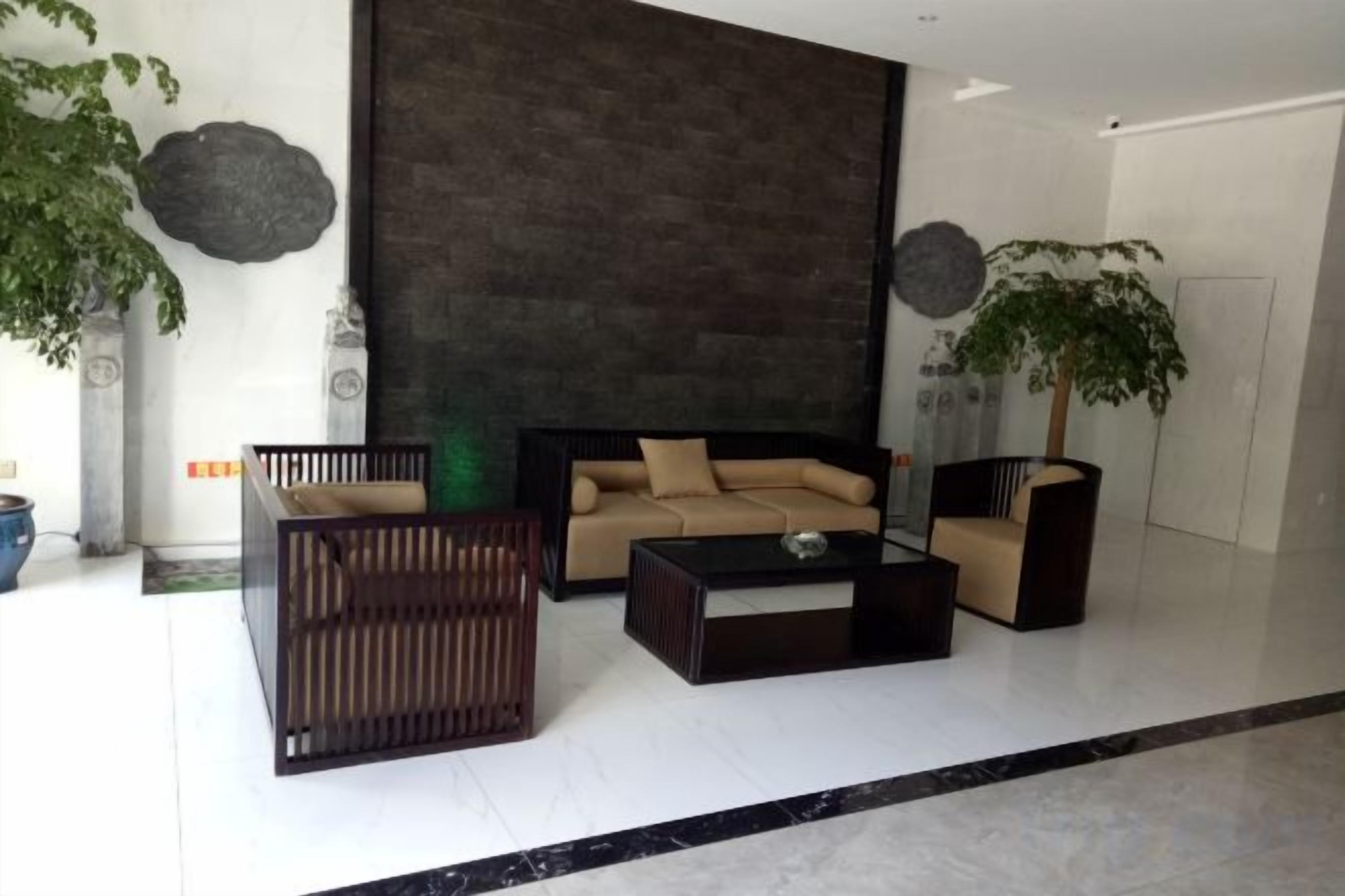 A modern living room with a sofa, coffee table, and a plant.