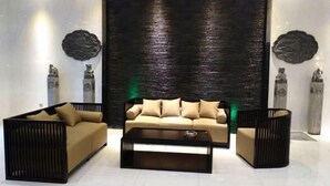 Una sala moderna con un sofá, dos sillones y una mesa de centro.