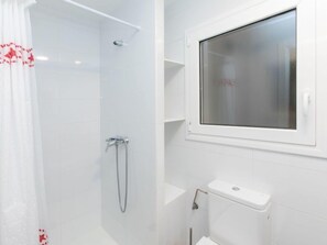 A modern bathroom with a shower, toilet, and a window. - Apartment Estiu by Interhome (L'Escala)