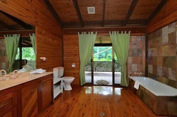 A wooden cabin bathroom with a toilet, sink, and bathtub. - WaitaWhile Eco Retreat - Holiday sustainably, pool, walk to beach (daintree)
