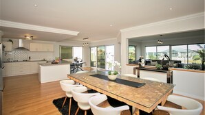 A spacious kitchen with a large island, white cabinetry, and a view to the outside.
