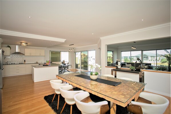 A spacious kitchen with a large island, white cabinetry, and a view to the outside.