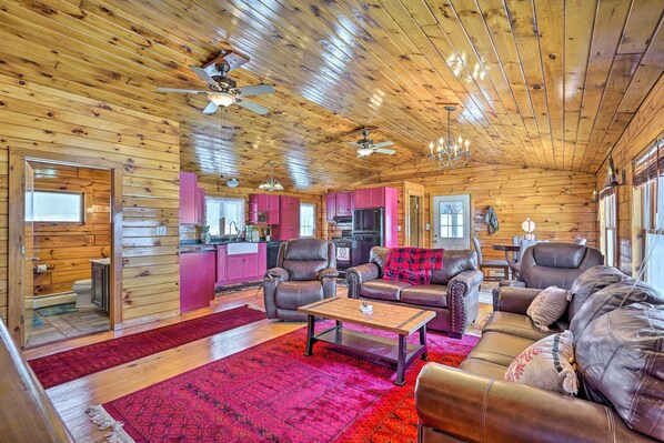 A log cabin interior with a living room, kitchen, and bathroom.