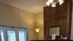 A cozy living room with a fireplace, wooden walls, and a bench by the window. - Foster - Nature Retreat -  Nippards Nature Cottage (Woorarra West)