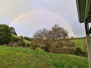 A rural landscape with a rainbow arching over a hill. - Foster - Nature Retreat -  Nippards Nature Cottage (Woorarra West)