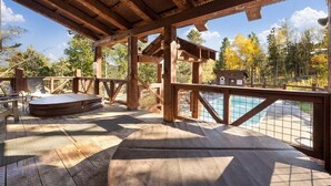 An outdoor deck with a pool, wooden deck, and a hot tub.