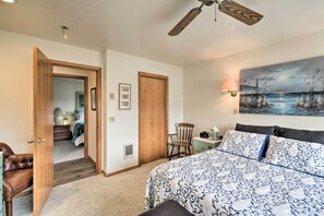 Une chambre à coucher avec un lit, une chaise, un bureau et un tableau accroché au mur.