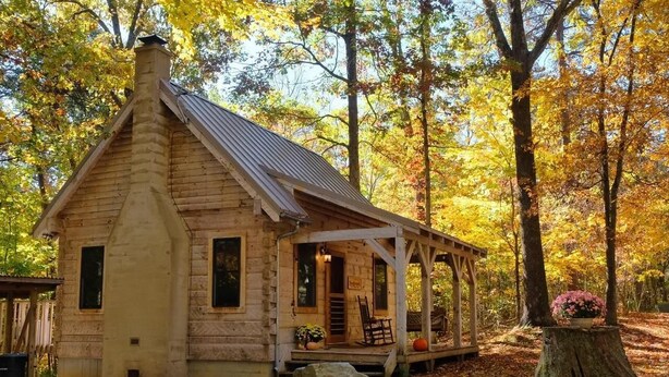 A rustic log cabin with a porch, surrounded by autumn foliage. - Tanglewood Cabin in Hocking Hills (with WiFi) (Rockbridge)