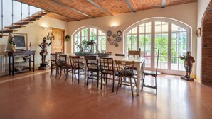A spacious dining area with a brick ceiling, large arched windows, and a rustic wooden table and chairs. - La Bell'aria by Interhome (Frinco)