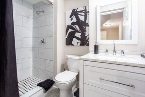 A bathroom with a shower, toilet, and sink. - THE GAMER-4BR Home-Near Everything ATL (Atlanta)