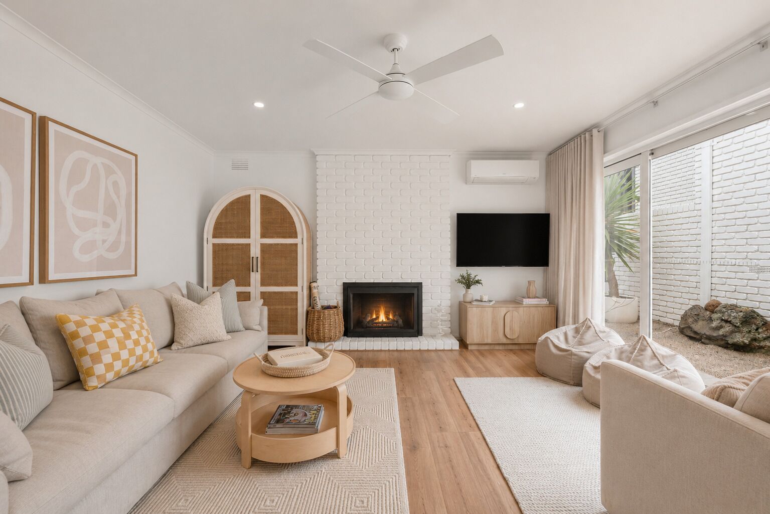 A modern living room with a fireplace, a sofa, a coffee table, and a TV mounted on the wall.