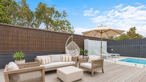 A wooden deck with outdoor furniture, a hanging chair, and a pool. - Boutique Retreat Portsea by Ready Set Stay (Portsea)