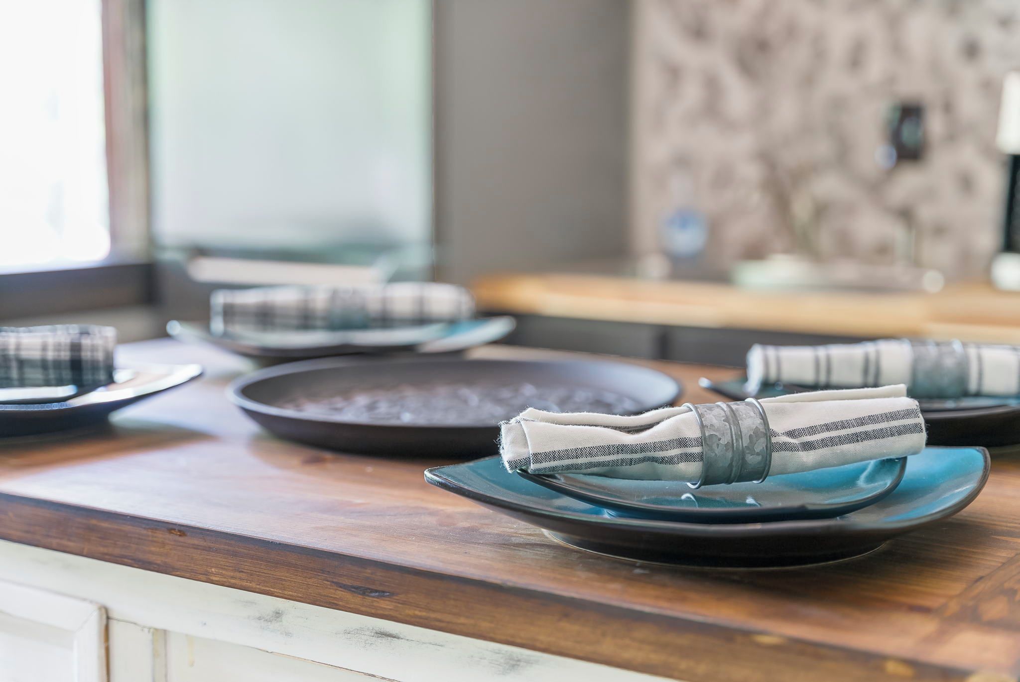 A dining table with plates and napkins.