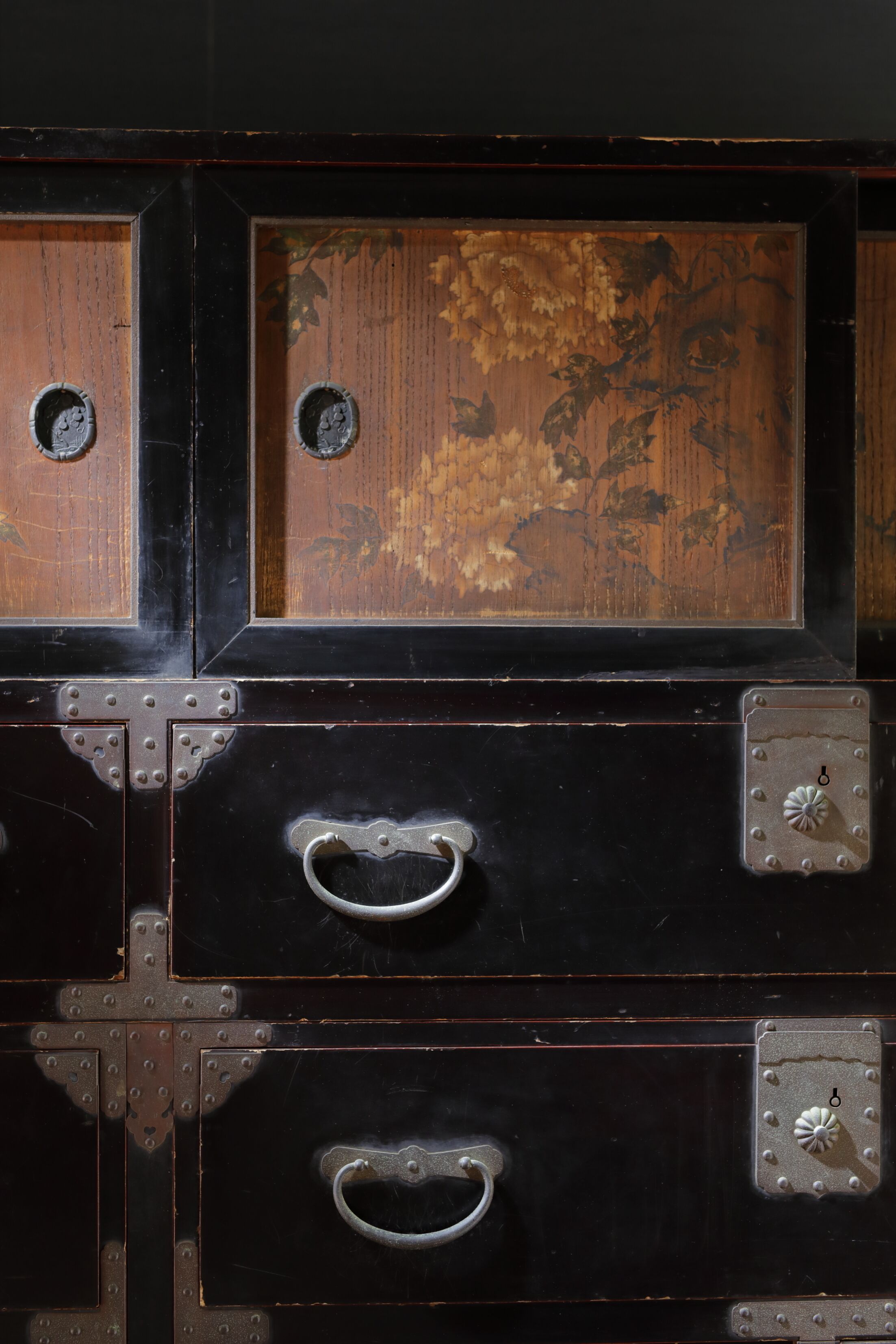 A large, dark wooden cabinet with metal handles and decorative metal plates.