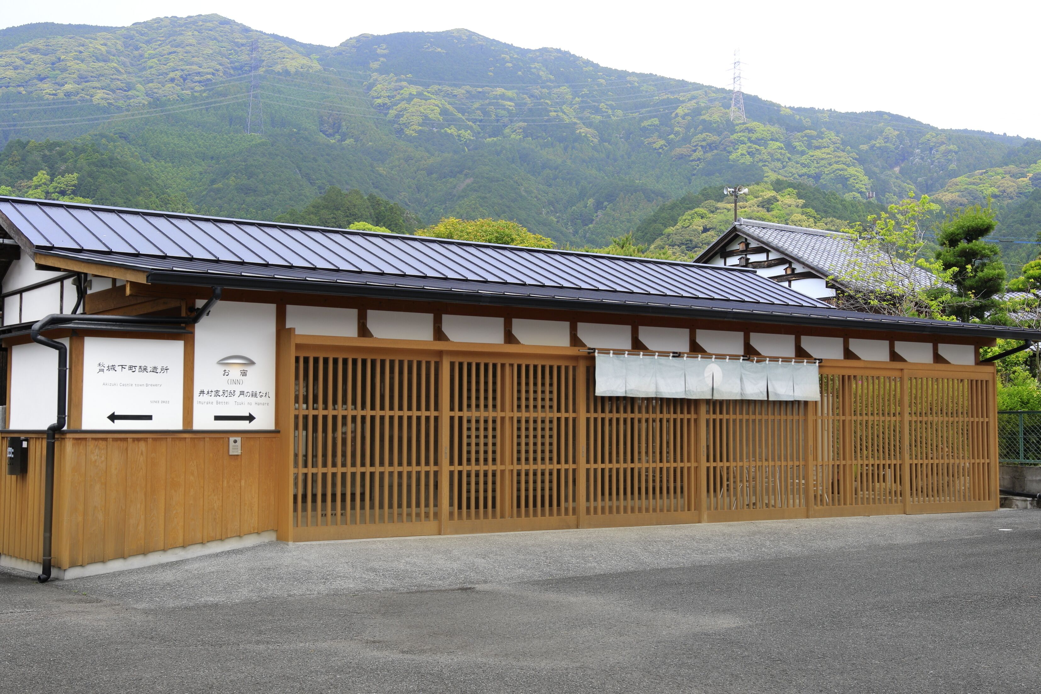 Un edificio japonés tradicional con tejado inclinado, puertas correderas de madera y un letrero que indica una casa de té.