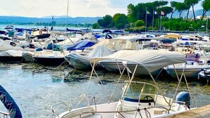Ein Yachthafen mit mehreren vertäuten Booten, umgeben von Bäumen und Hügeln im Hintergrund.