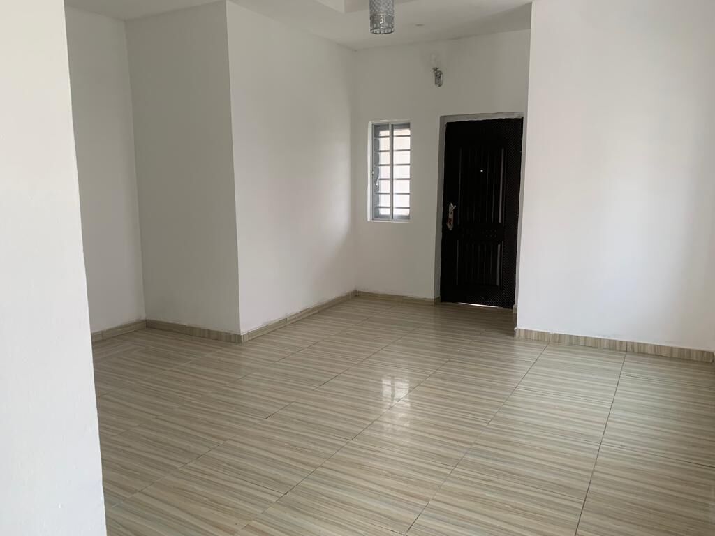 Una habitación amplia con suelo de baldosas, una ventana y una puerta.