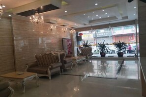 A lobby with seating, chandeliers, and a view of the street. - Bo Yue Hotel (Zhongshan)