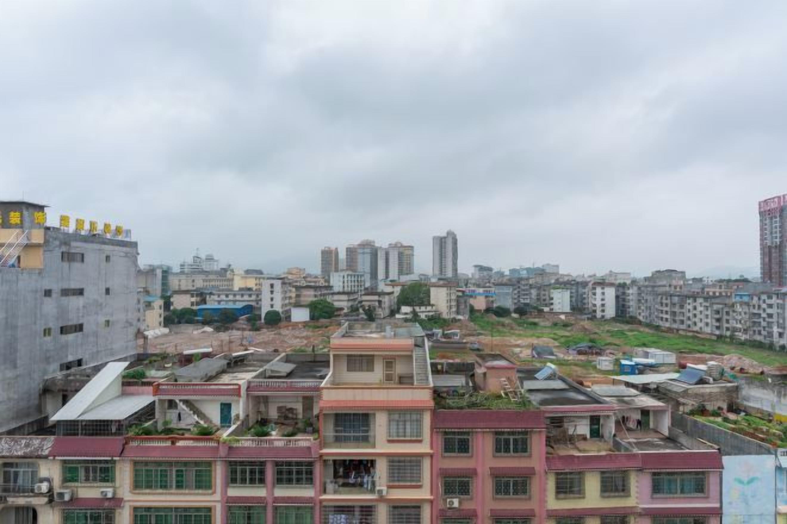 Un paisaje urbano con una mezcla de edificios residenciales y comerciales, incluyendo una torre alta destacada.