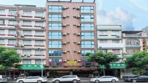 Un hotel de varios pisos con un diseño vertical central, con balcones en cada planta.