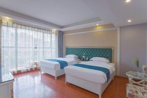 Una habitación de hotel con dos camas, una mesita y una silla.