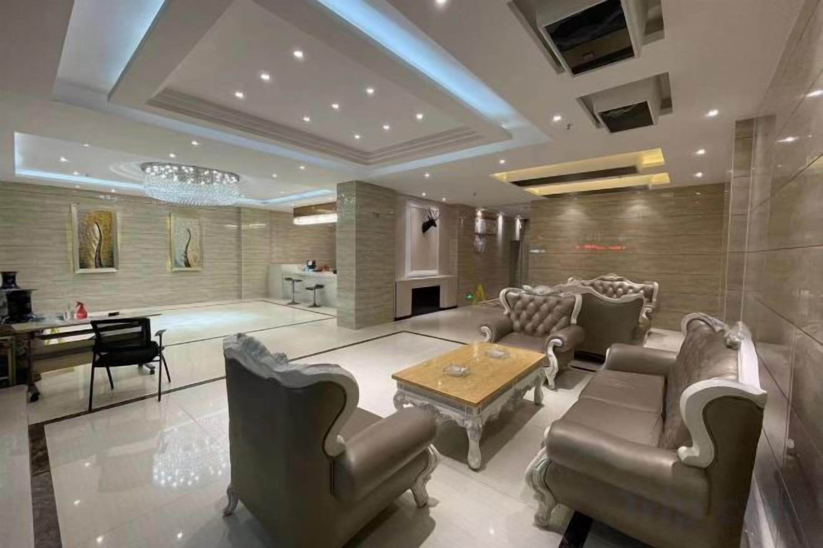 A spacious living room with a fireplace, leather sofas, and a coffee table.