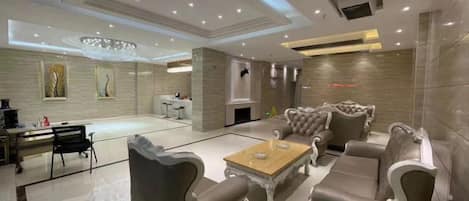 A spacious living room with a fireplace, leather sofas, and a coffee table.
