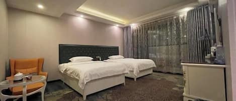 Quarto de hotel com uma cama, uma cadeira, uma mesinha e um armário.