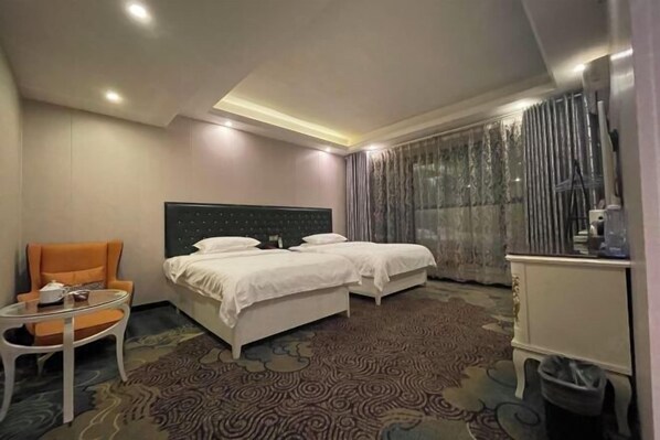 Una habitación de hotel con una cama, una silla, una mesita y un armario.