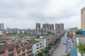 A cityscape with high-rise buildings, a road with vehicles, and a clear sky. - Bo Yue Hotel (Zhongshan)