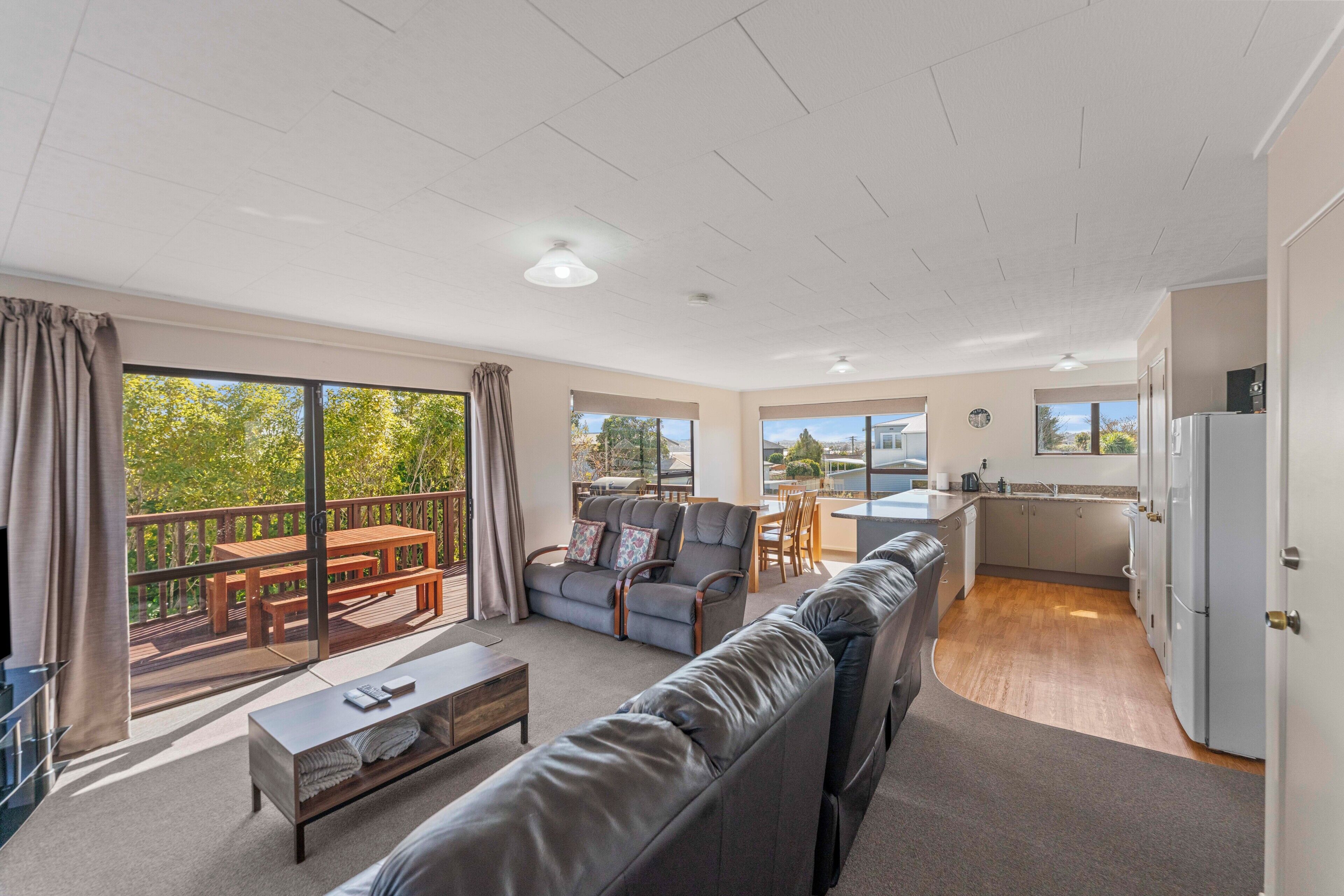 A spacious living area with a sofa, a dining table, and a kitchen area.